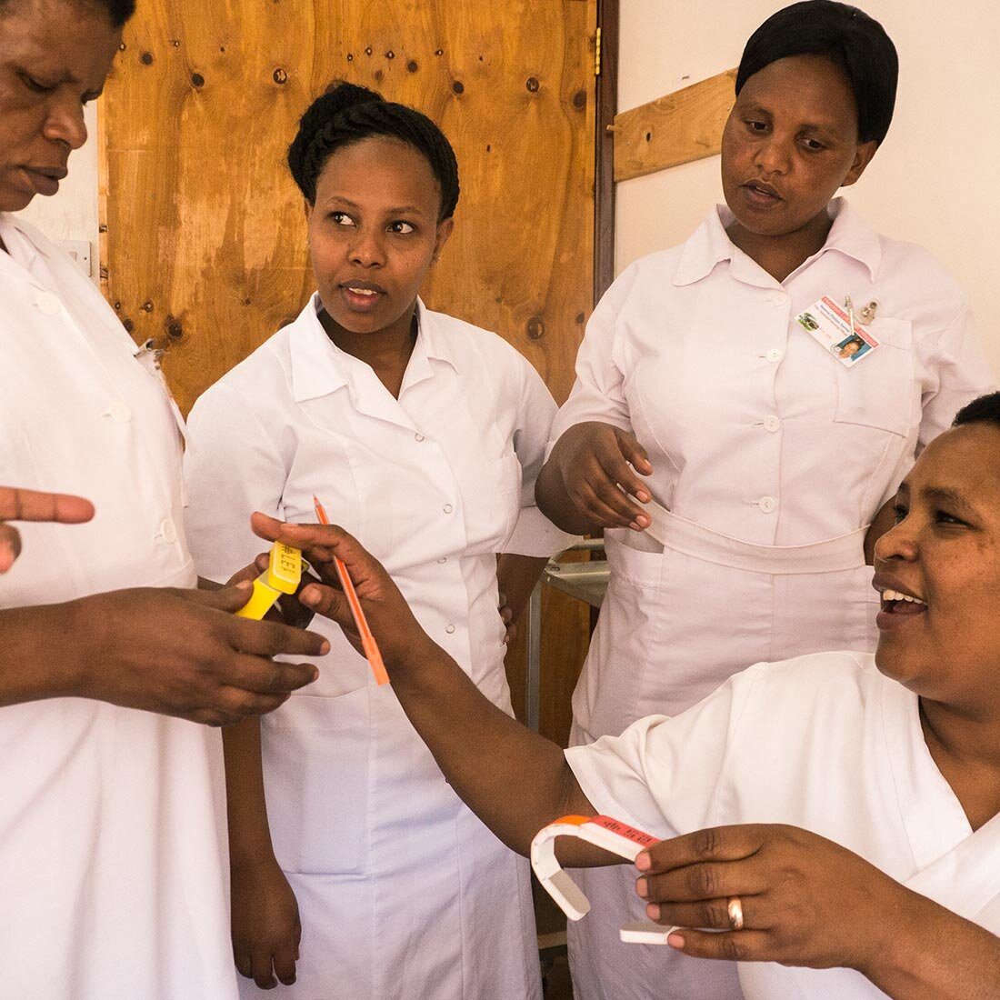 Fire uniformerte sykepleiere studerer utstyr og sender det mellom seg.