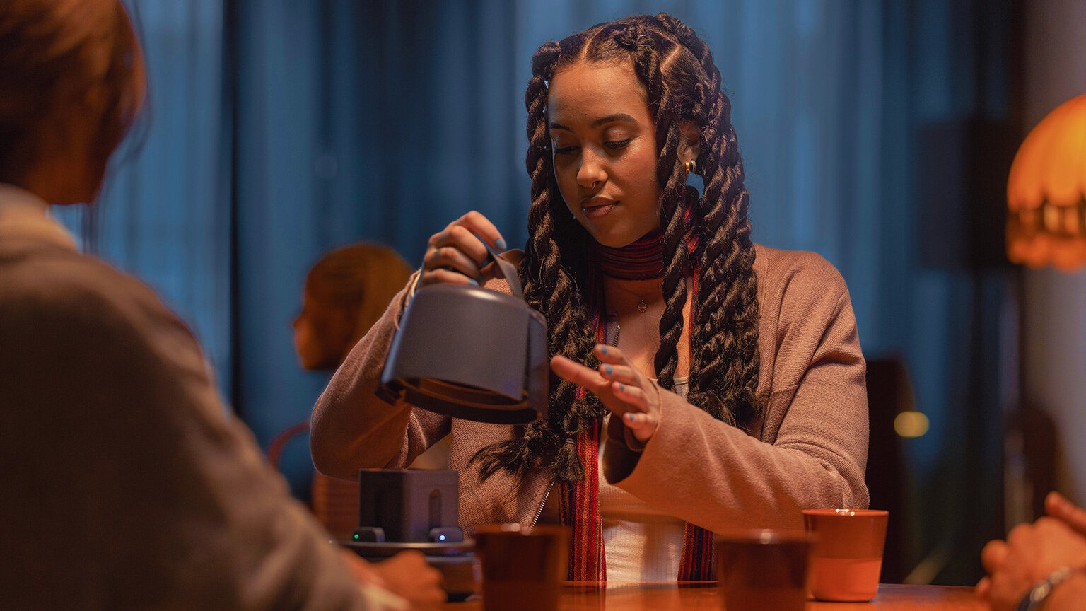 Ung dame sitter inne og åpner Nomono-boksen på et bord.