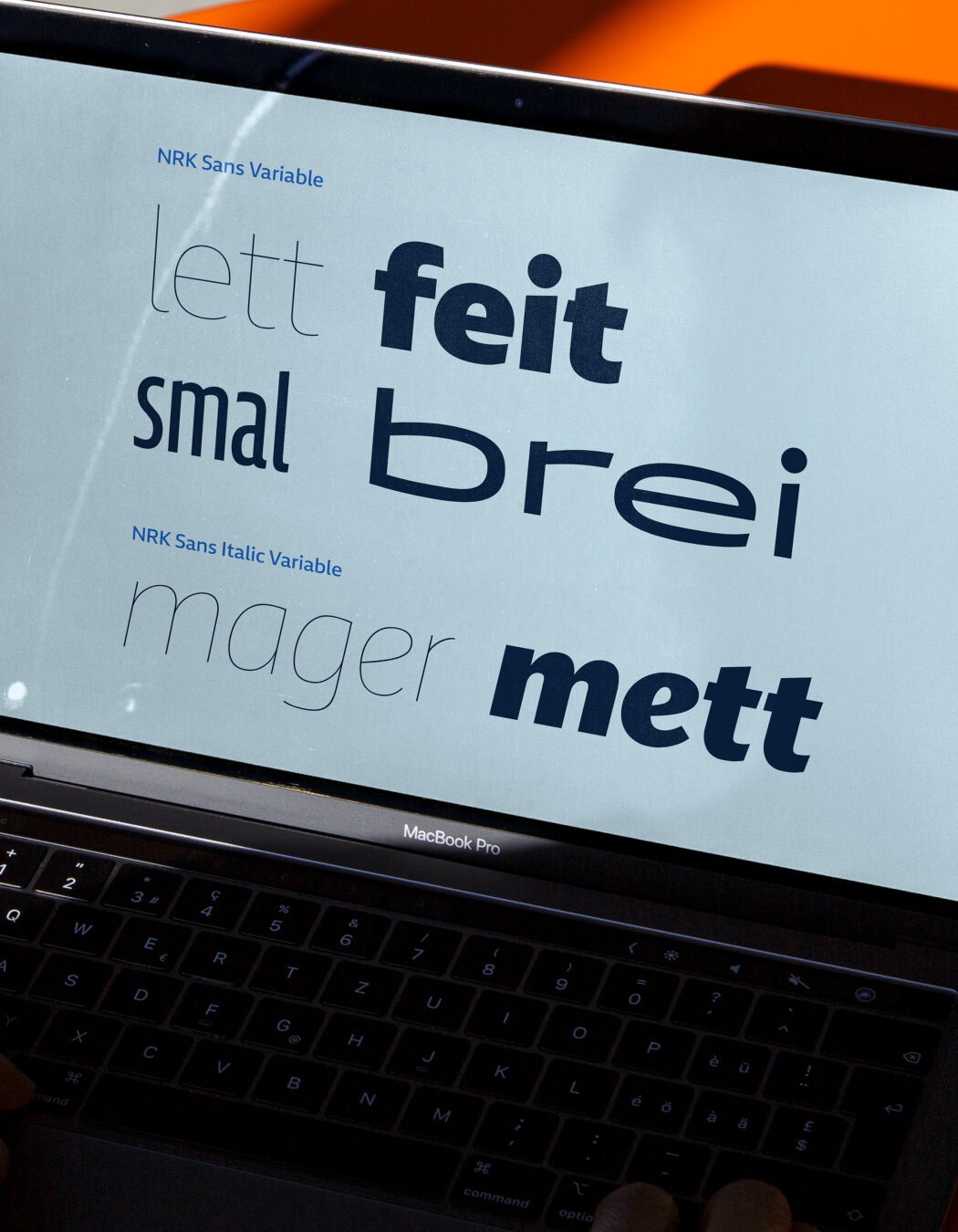 En Macbook Pro skjerm som viser fonten NRK Sans Variable i ulike variasjoner, med uten og med kursiv.