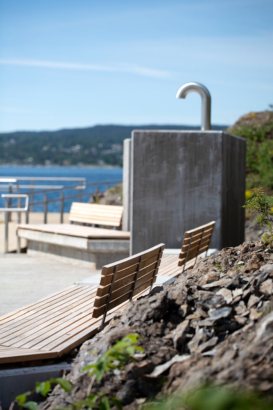 Sittebenker innfelt i en skrent. Fjorden skimtes i bakgrunnen.