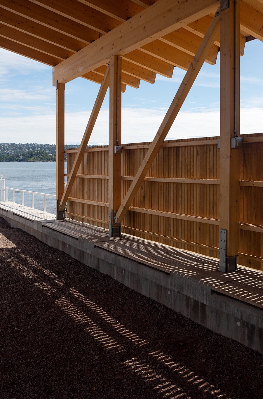 Åpent og overbygd venteskur med utsikt mot havet.