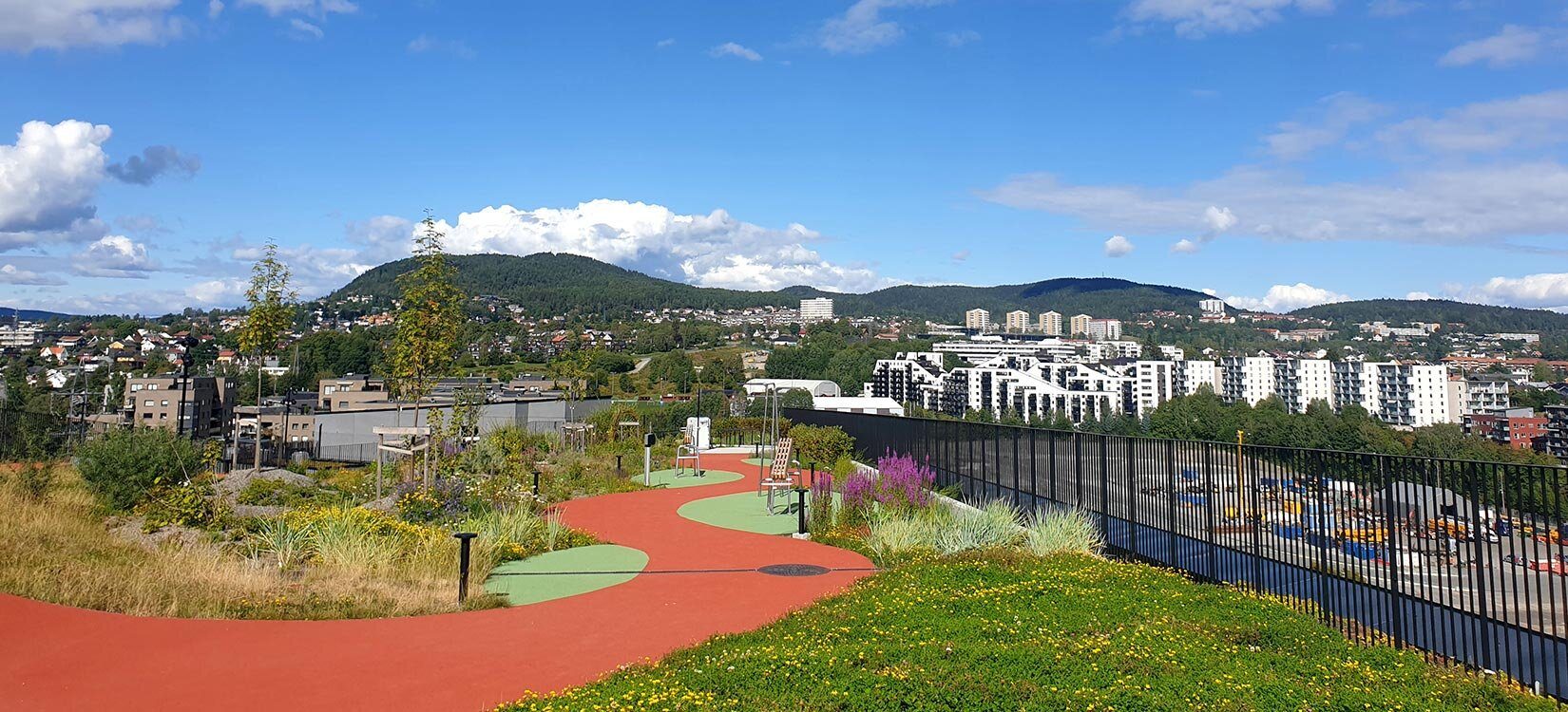 Takhage med løpebane og frodig beplantning