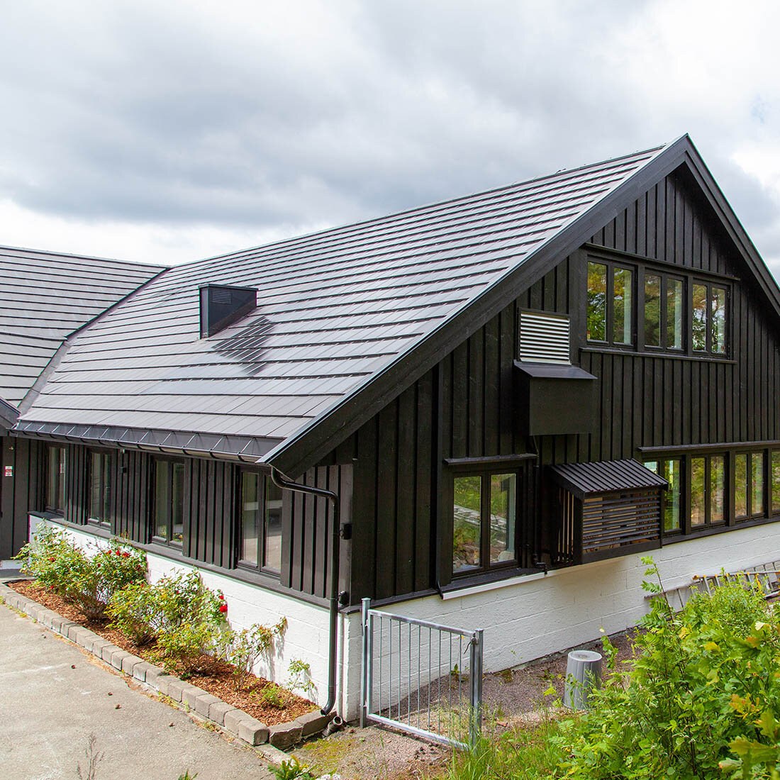 Bilde av et hus med skråtak, og blanke taksteiner.