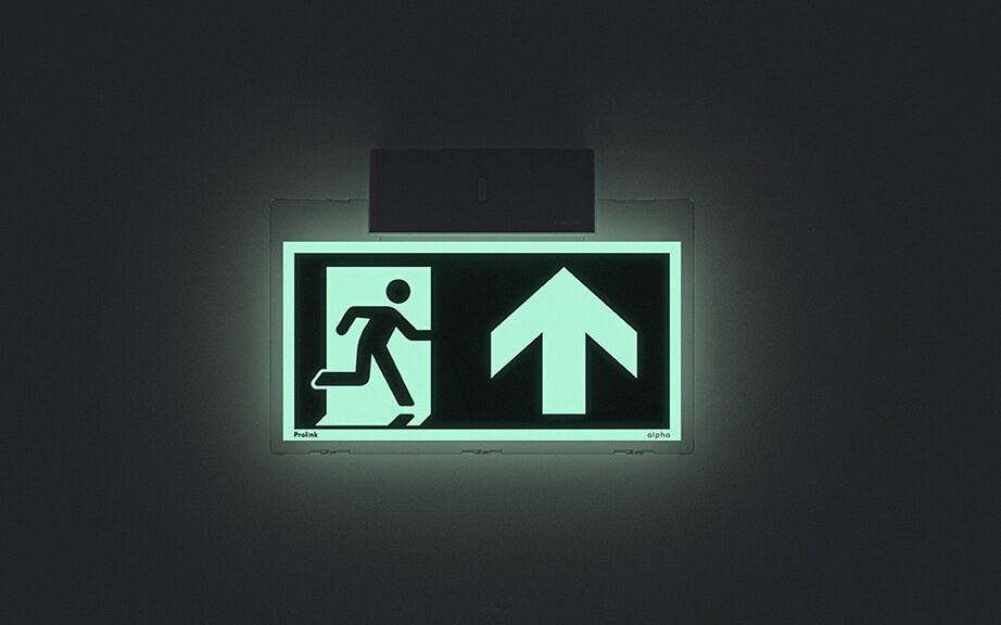 Nødutgangsskilt mot mørk bakgrunn.