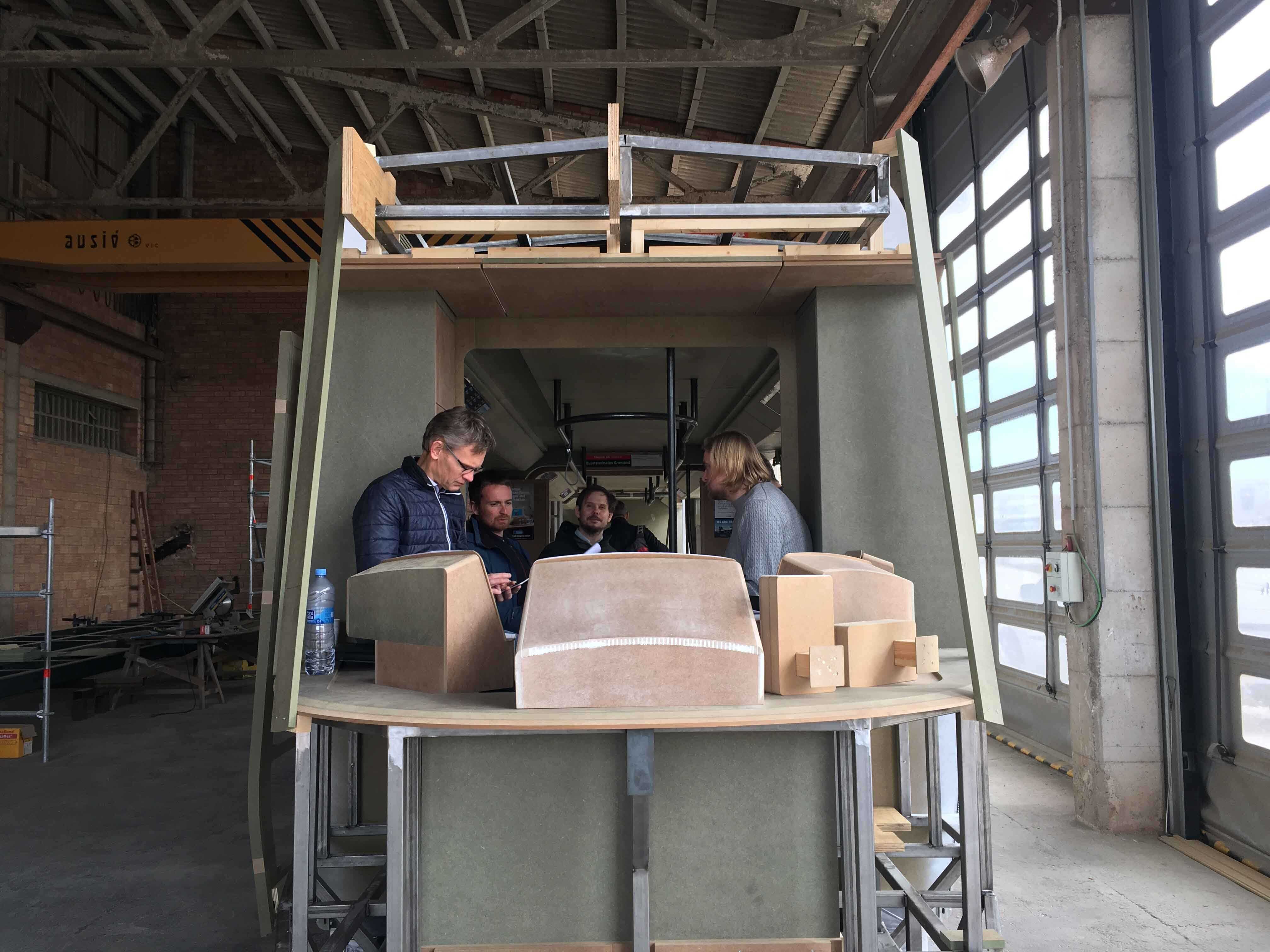 Personer deltar i medvirkningsprosess rundt en fullskala modell av SL18-trikken.