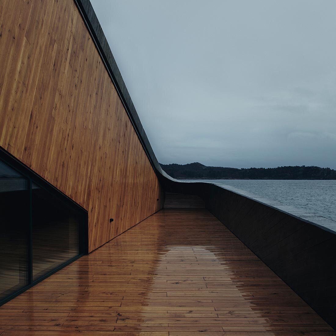 Eksteriørfoto fra en terrasse med vegger og gulv av vått trepanel.