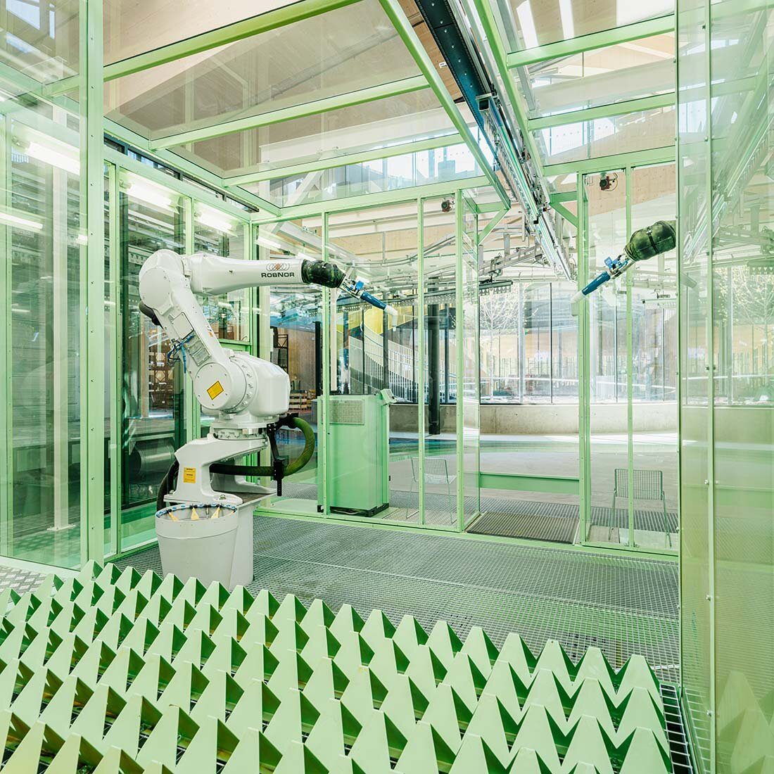 Lyse produksjonslokaler med grønnlakkerte detaljer.