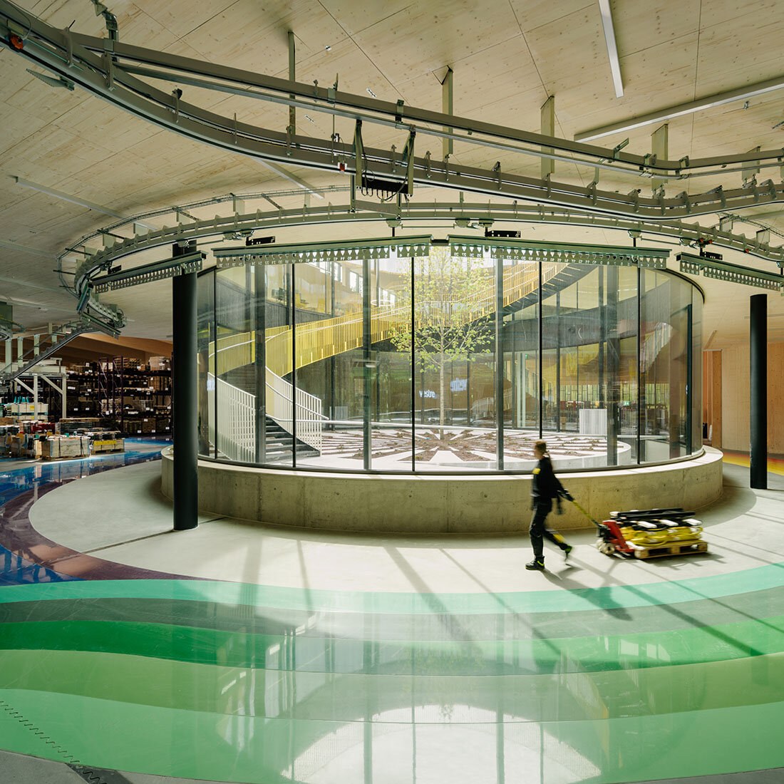 Interiørfoto fra midten av fabrikken med utsyn ut mot besøksområdet med tilkomst fra taket.