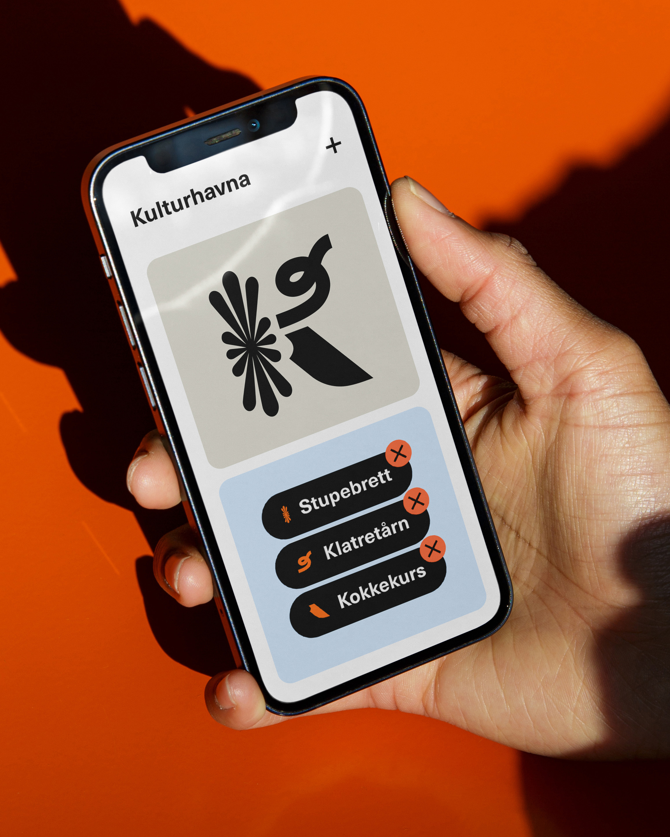 En hånd som holder en mobil med en app der man kan velge mellom tre alternativer