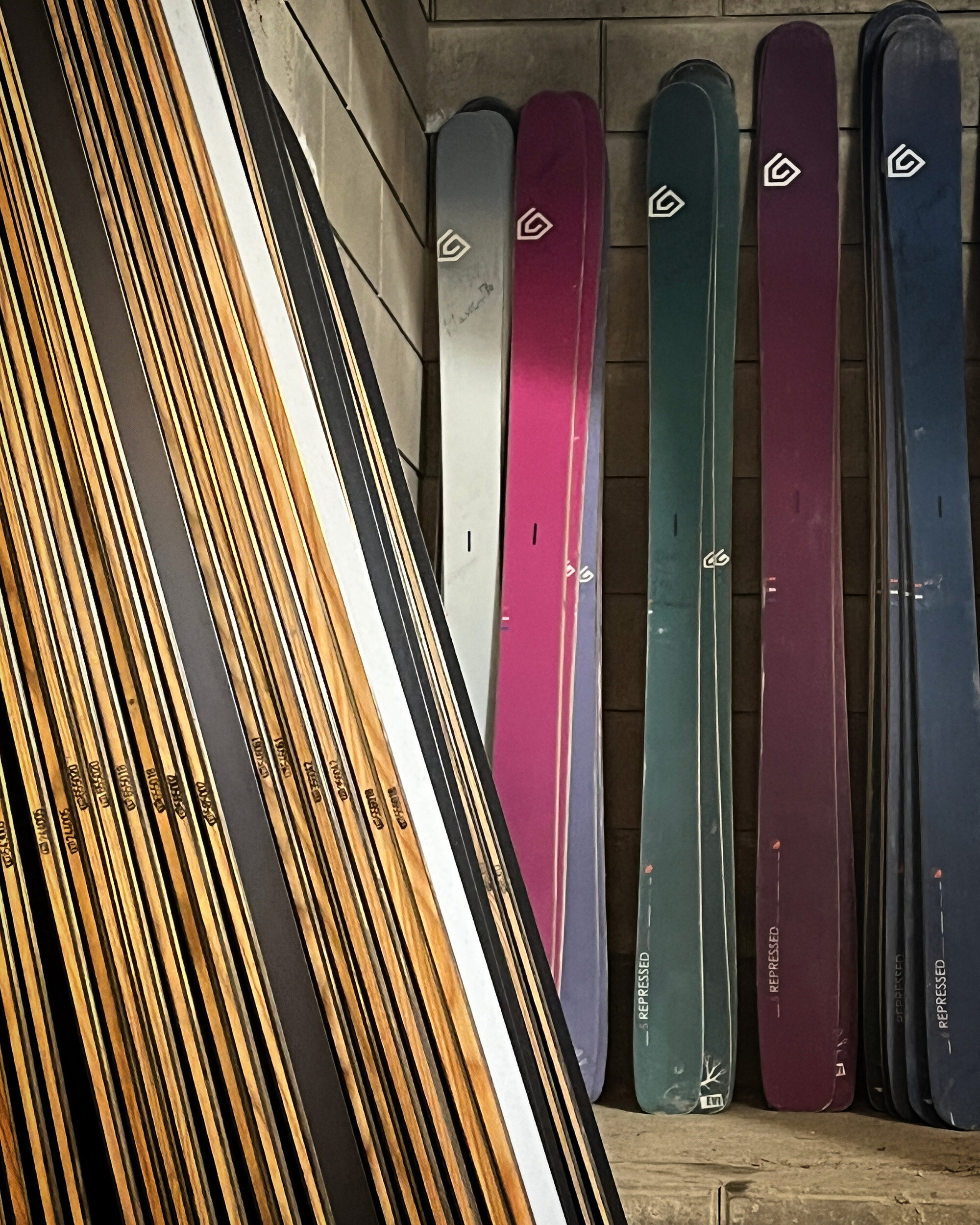 En mengde alpinski stablet utenpå hverandre i et rom.