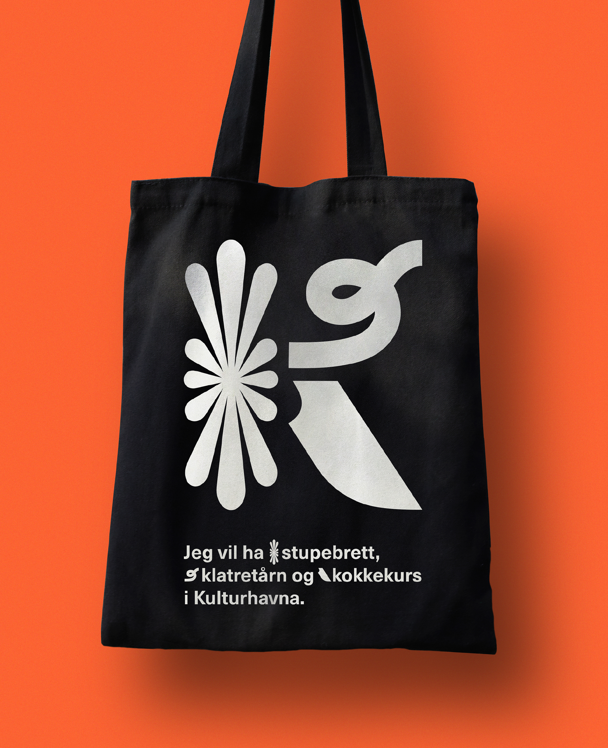 En sort totebag mot en oransje bakgrunn