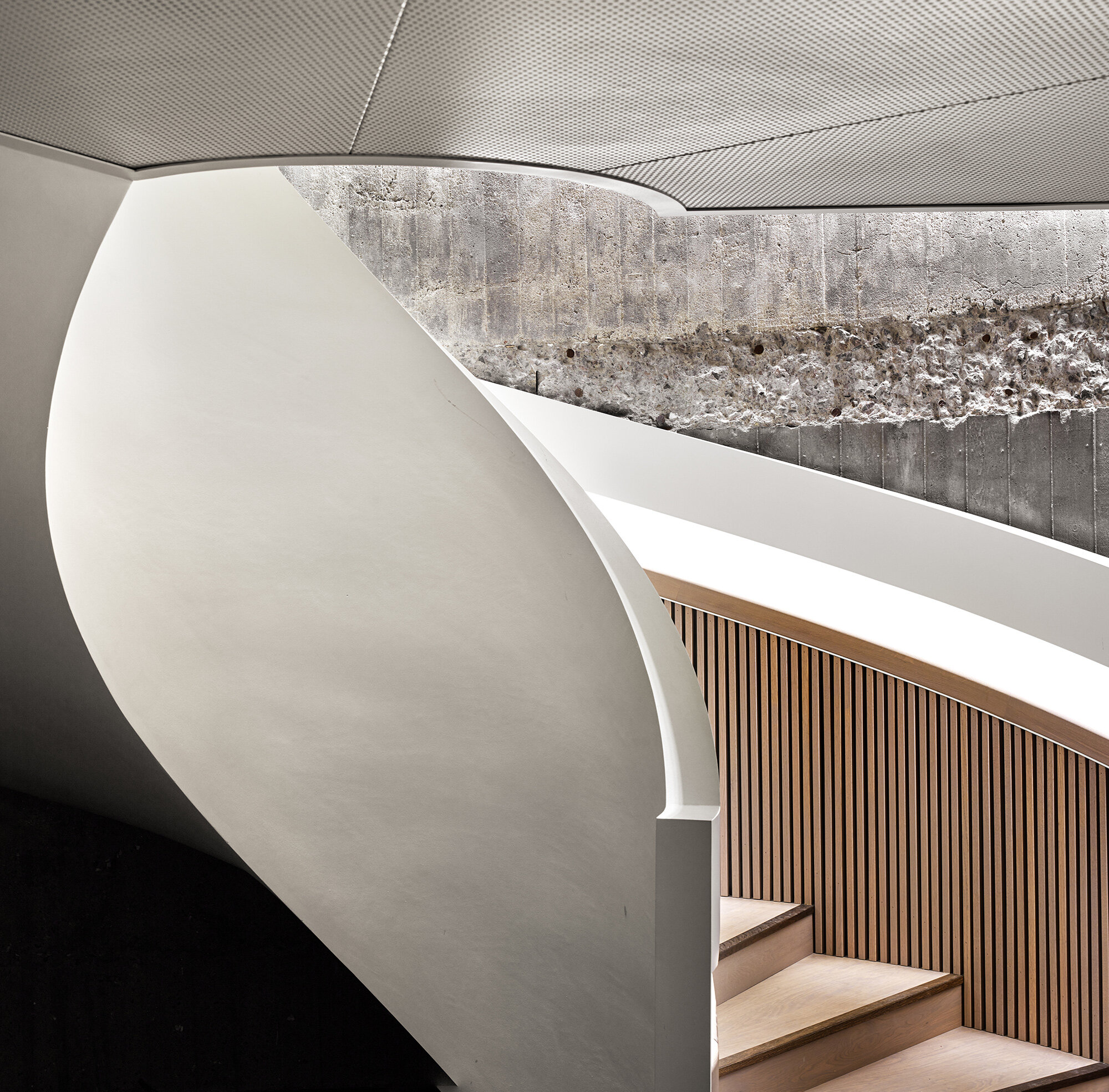 En skulpturell trapp i betong og tre.