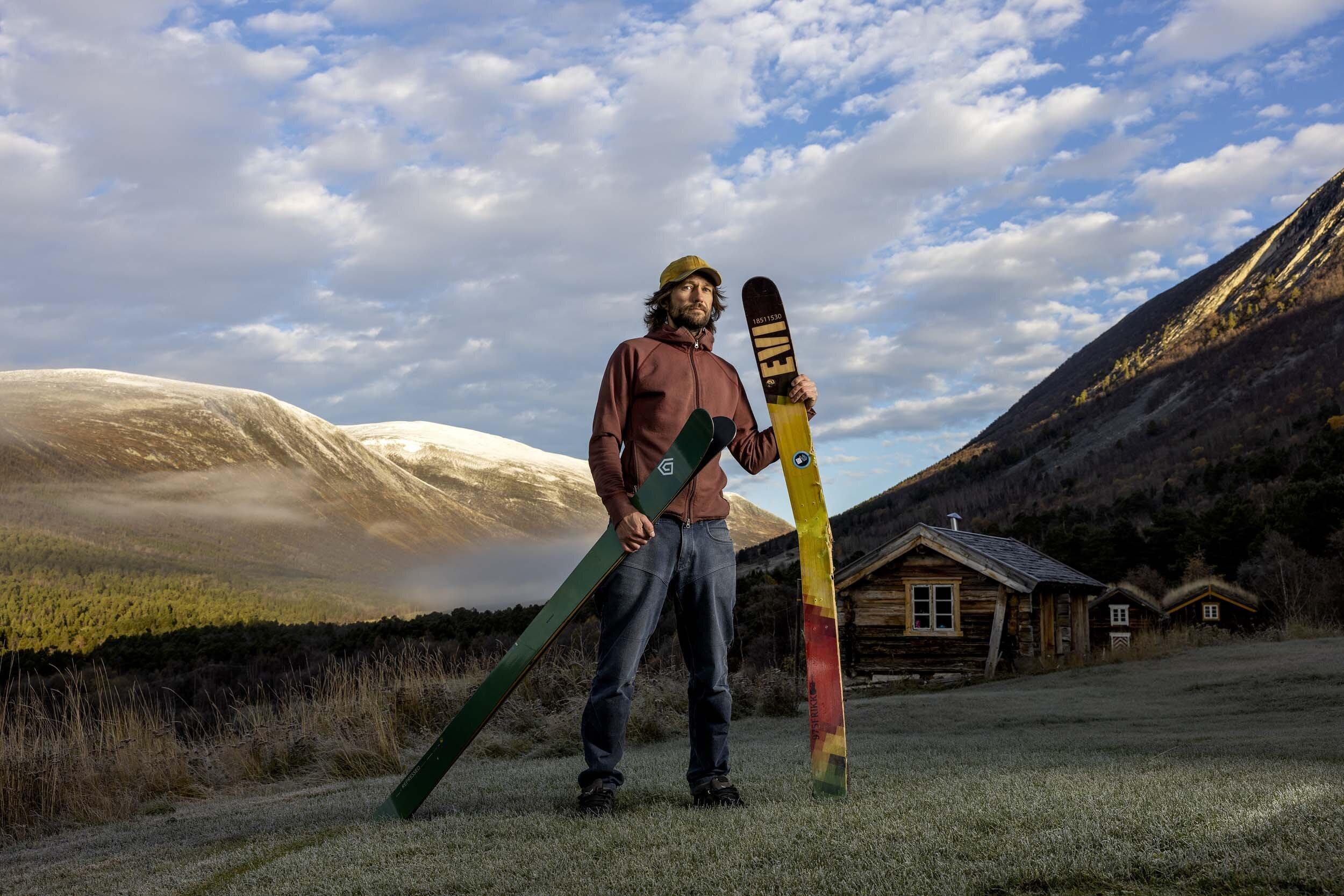 En alvolig mann med caps holder opp en knekt alpinski.