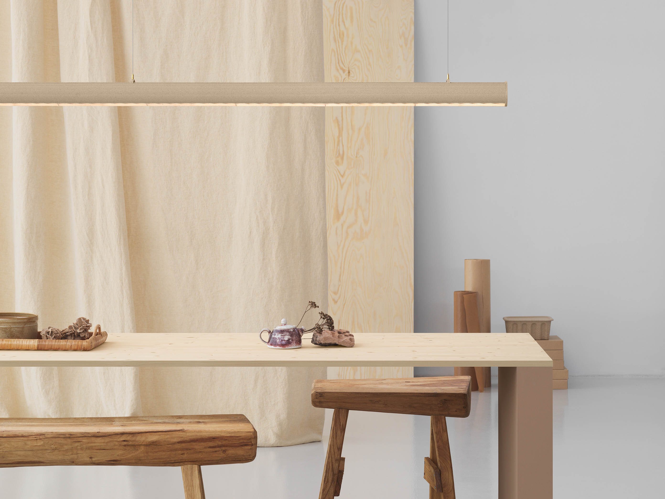 En smal trehvit bordplate med lampen Superdupertube hengende over.