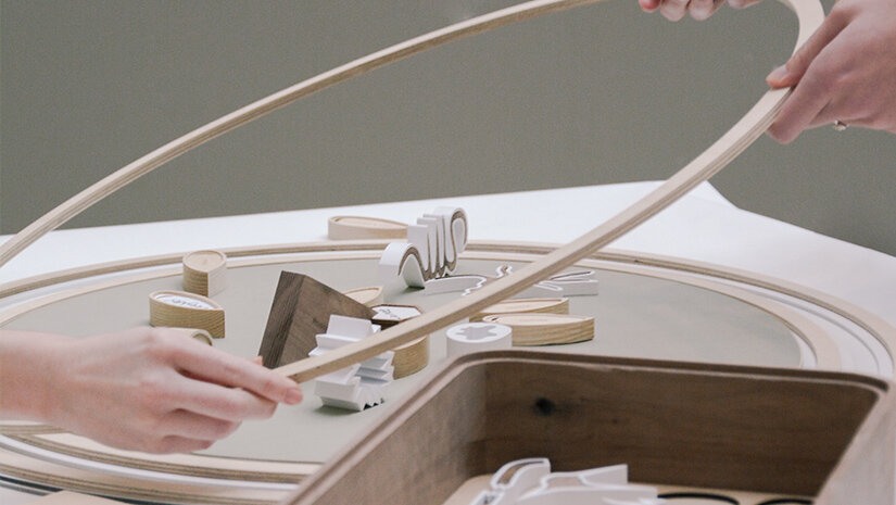 To hender løfter en trering som omgir klosser i forskjellige fasonger.