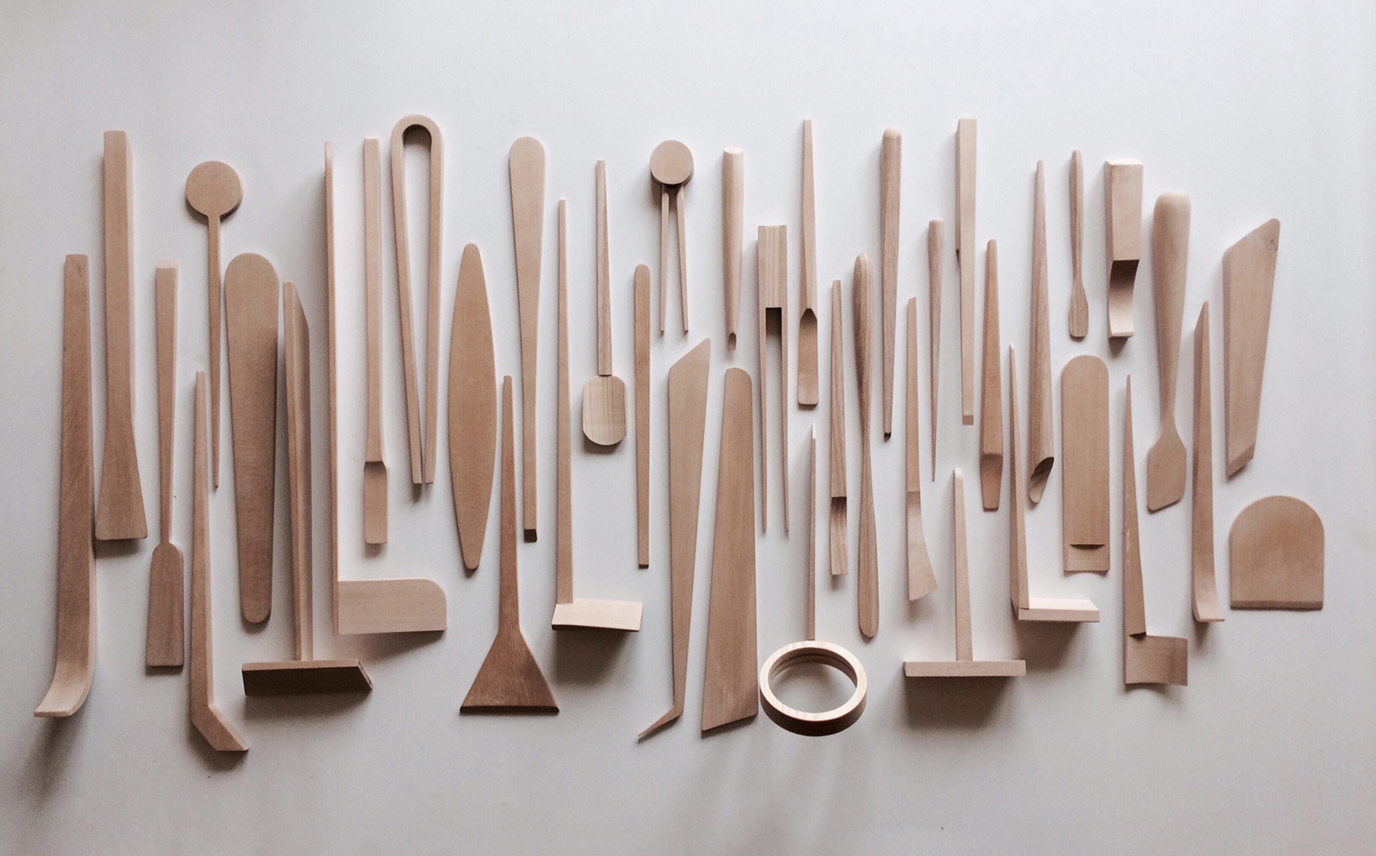 Foto av et stort antall abstrakte redskaper utført i naturlig treverk. Sirlig dandert og fotografert rett ovenfra.