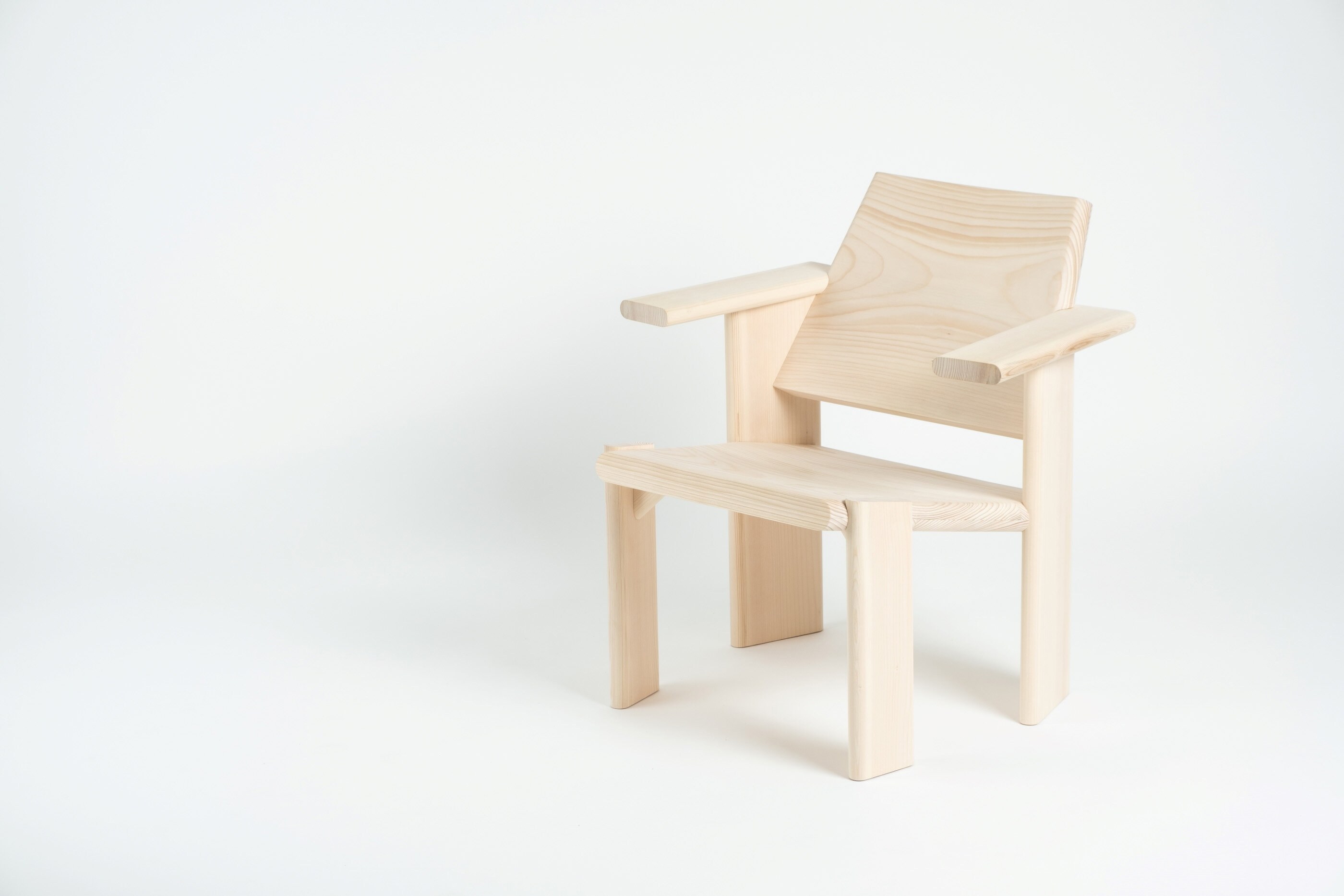En liten lenestol i ubehandlet tre mot en hvit bakgrunn.