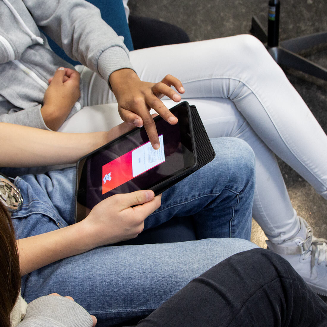 To ungdommer ser på og trykker på en ipad.