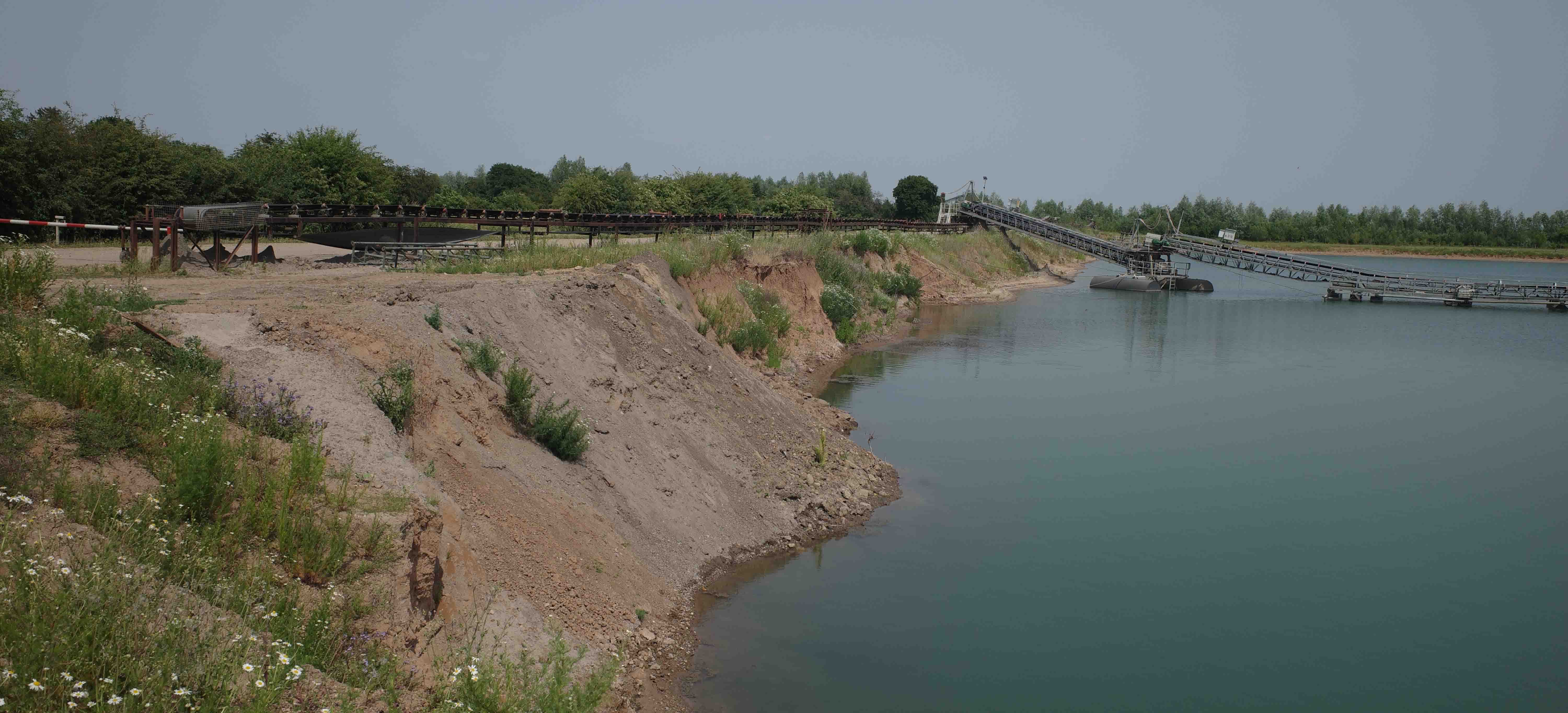 Landskap med sand og vann og rester etter gruvedrift.