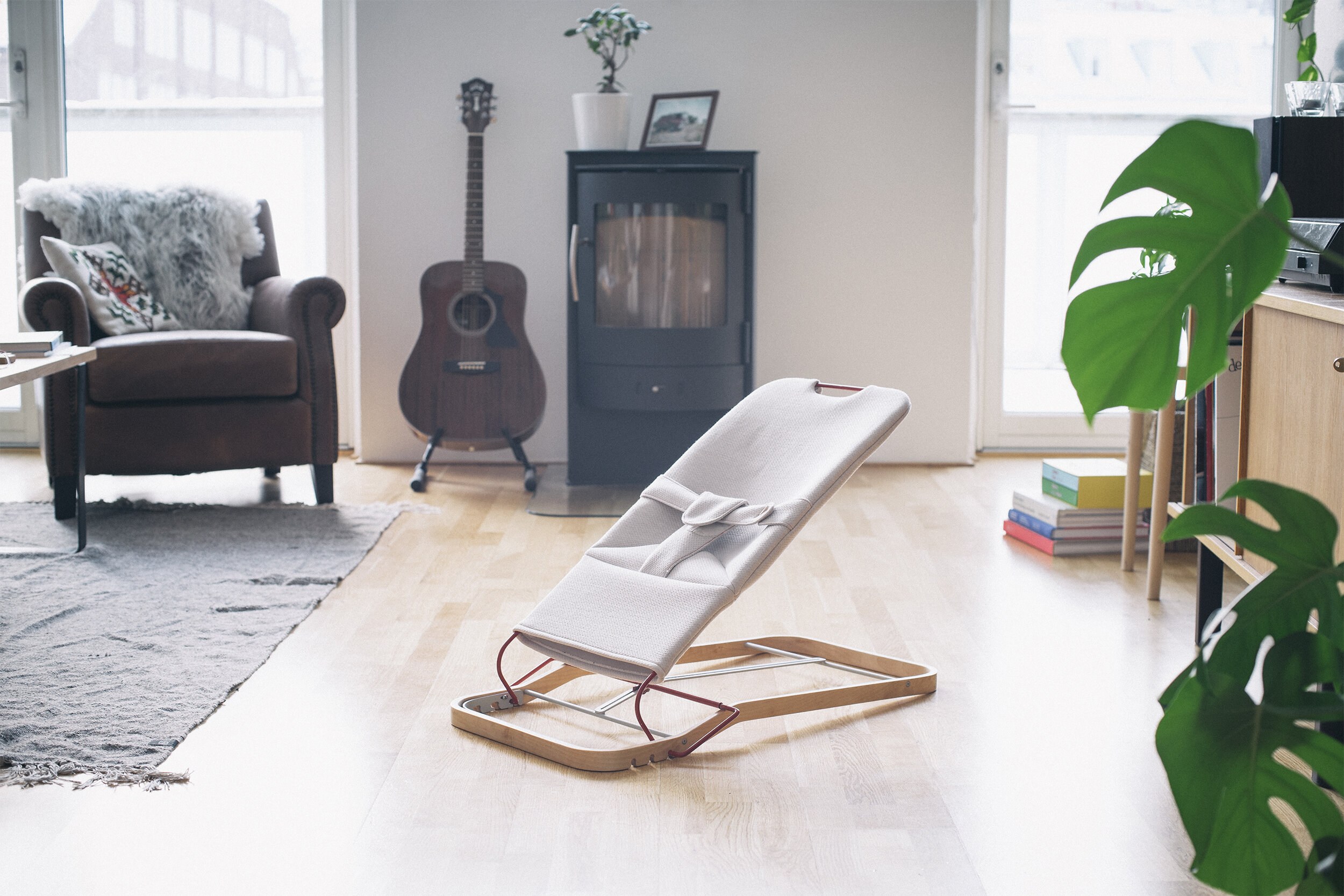 Et bilde av en vippestol på et enkelt stativ og hvitt tekstil i et hjemlig interiør.