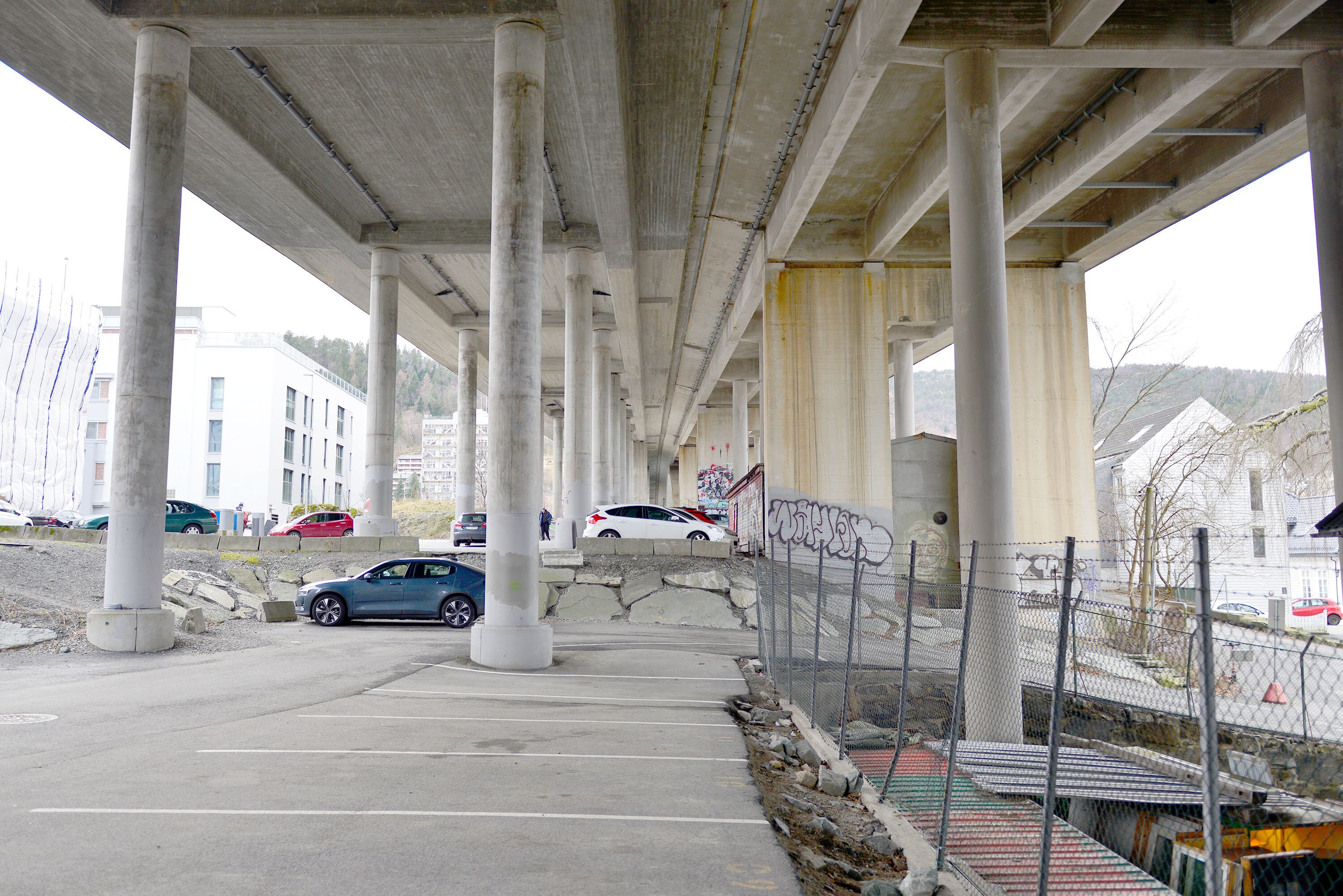 Parkerte biler under en stor motorveibru.