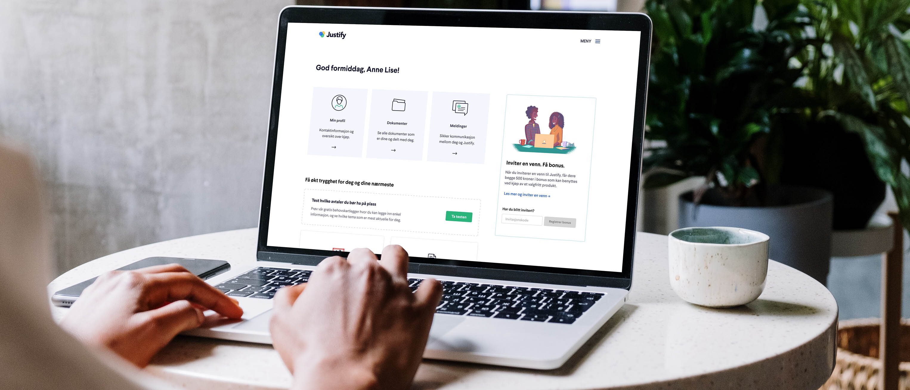 Hender på tastaturet på en mac som har Justify sin nettside åpen.