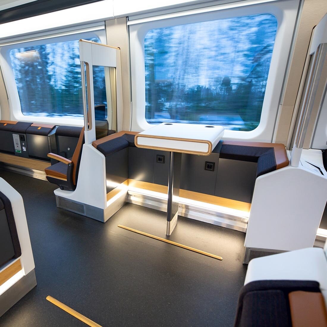 Et oppholdsareal på en av Flytogets vogner med "barkrakker" og et høyt bord med to koppholdere.