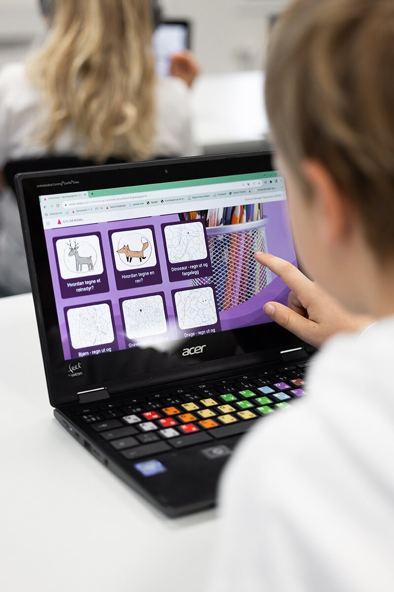Barn sitter ved en bærbar PC som viser dyreillustrasjoner i Salaby
