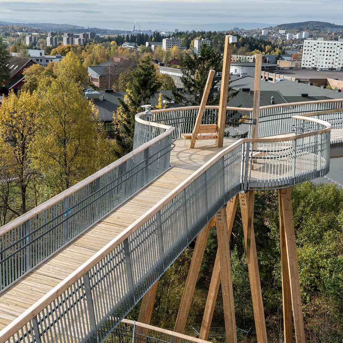Møteplass i løypen på vei mot toppen av Stovnertårnet. I bakgrunnen ses løvskog, og spredt blandet bebyggelse som strekker seg inn i horisonten.