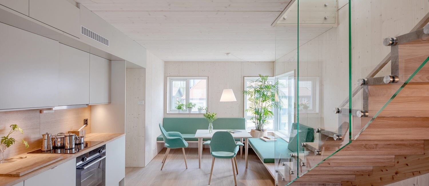 Interiørfoto av et moderne lyst interiør med kjøkken og spisestue.