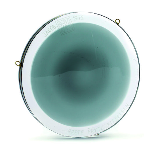 Foto av Jacob prisens runde plakett i blågrønt, håndblåst glass fra Hadeland Glassverk.