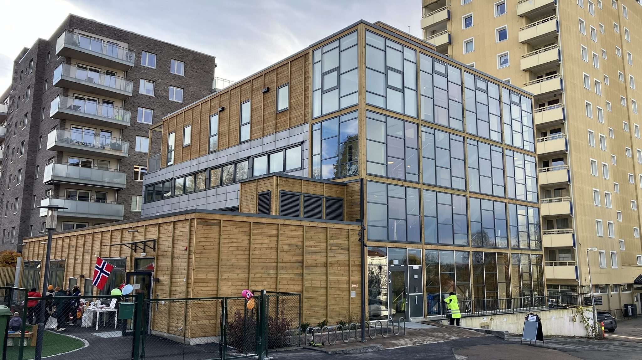 Bilde av en transformert bygning med en barnehage foran og eksisterende bebyggelse i bakgrunnen.