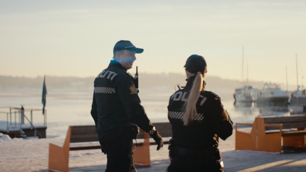 Foto av politimann og kvinne som går ute på patrulje.