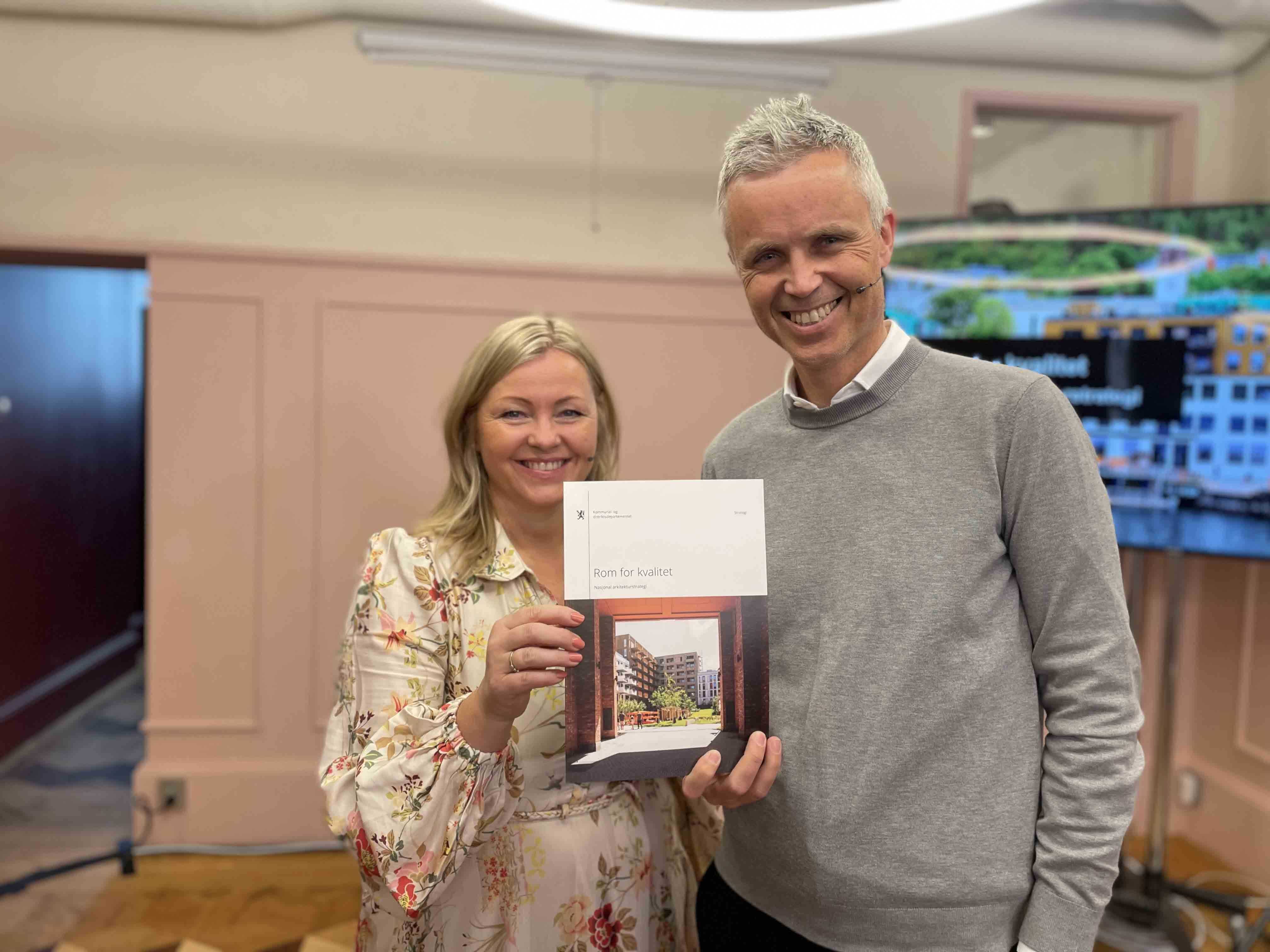 Foto av Kjersti Stenseng og Tor Inge Hjemdal som smilende holder opp strategidokumentet.