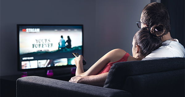 Couple sitting on couch streaming movies