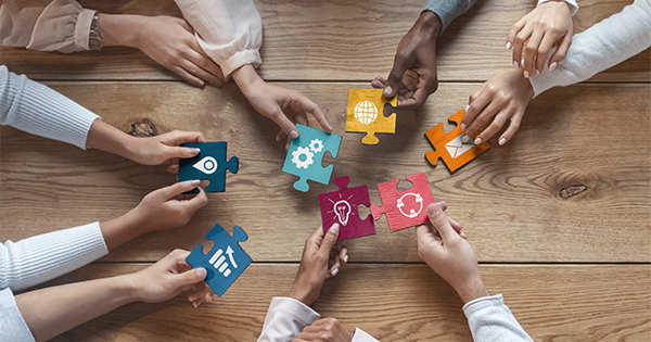 Diverse hands with puzzle pieces for technology