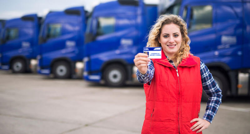 woman truck driver proudly holding commercial driving license