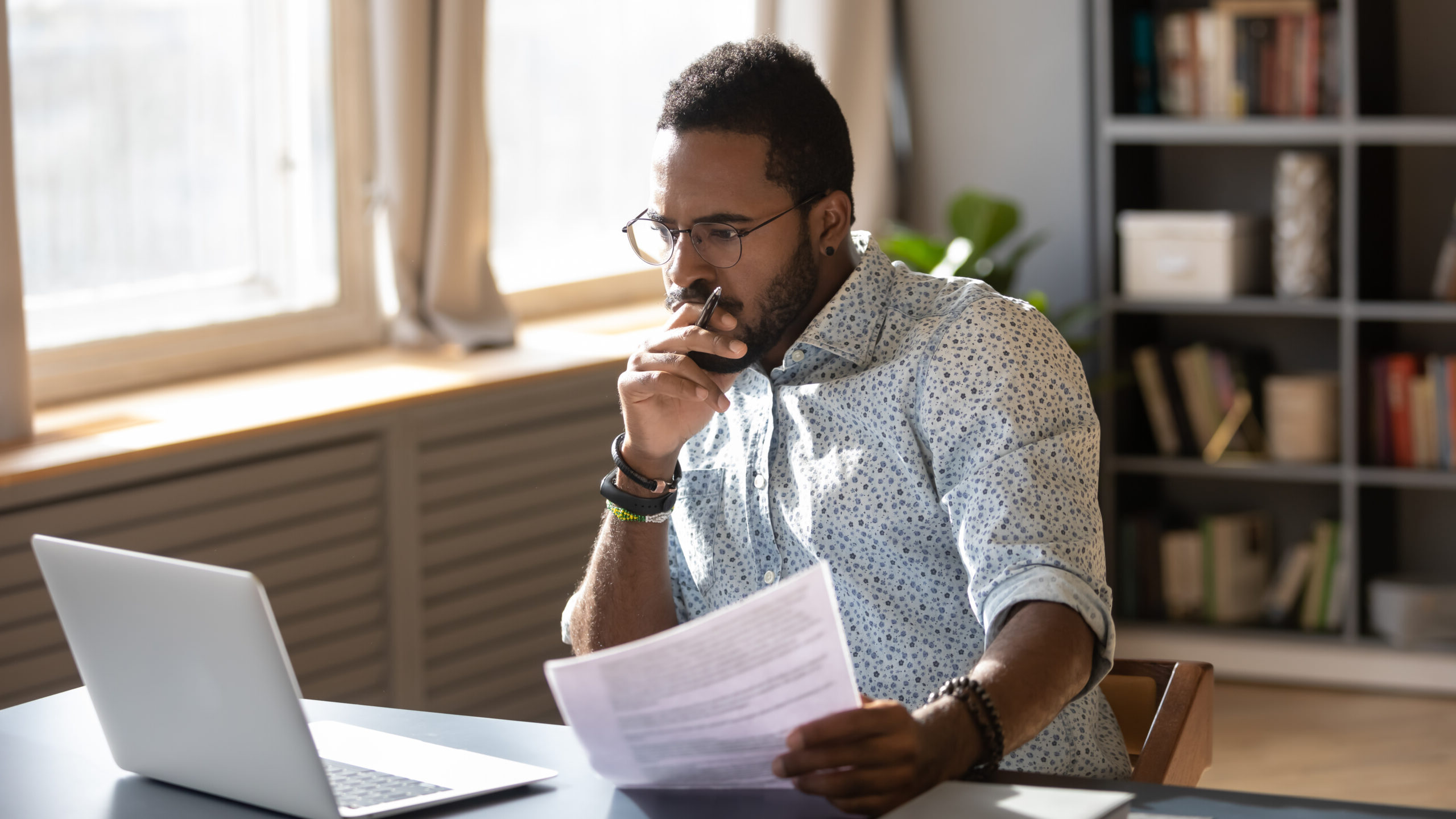 Man working in the office on laptop examining a background check