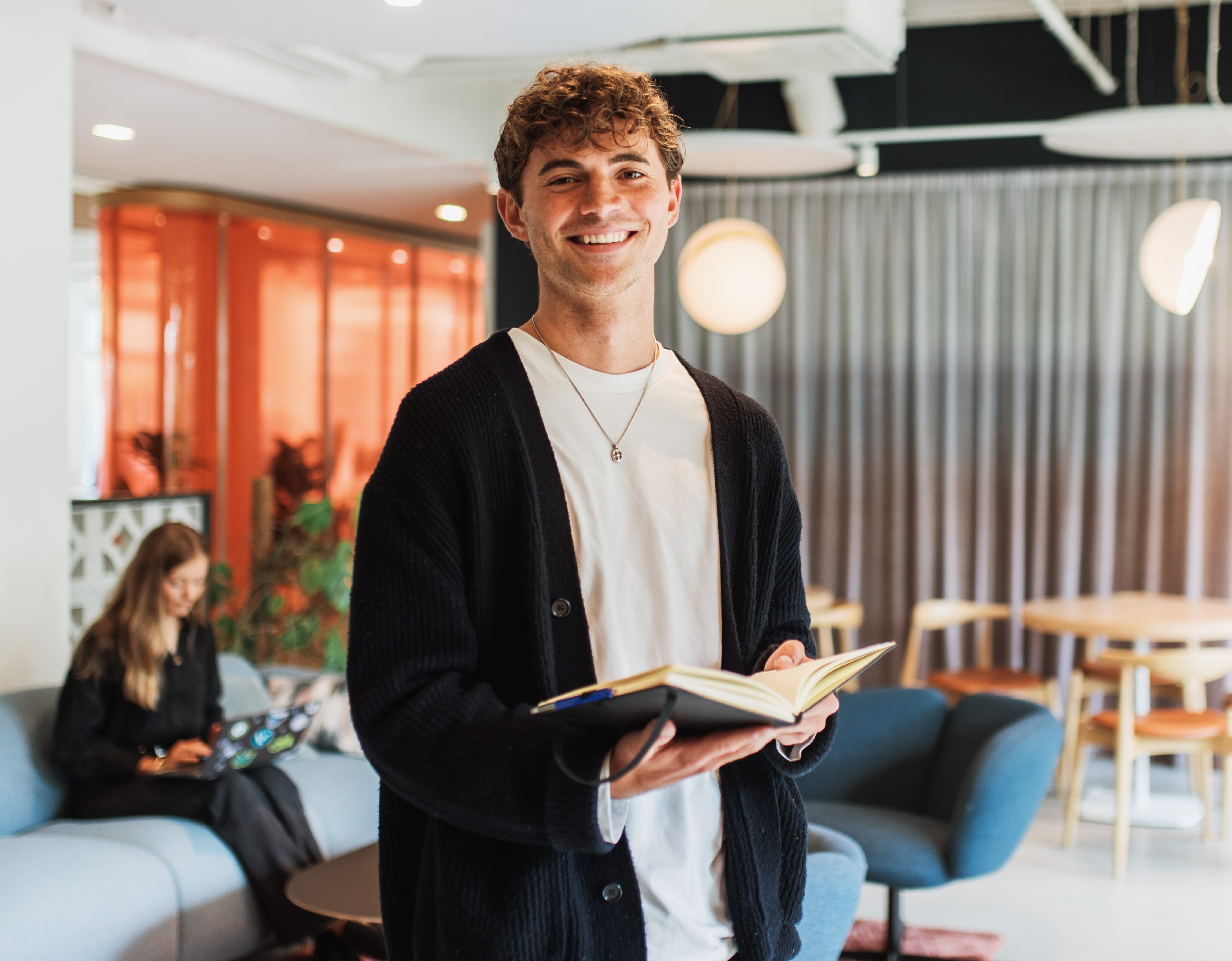 Man in an office environment holding a notebook