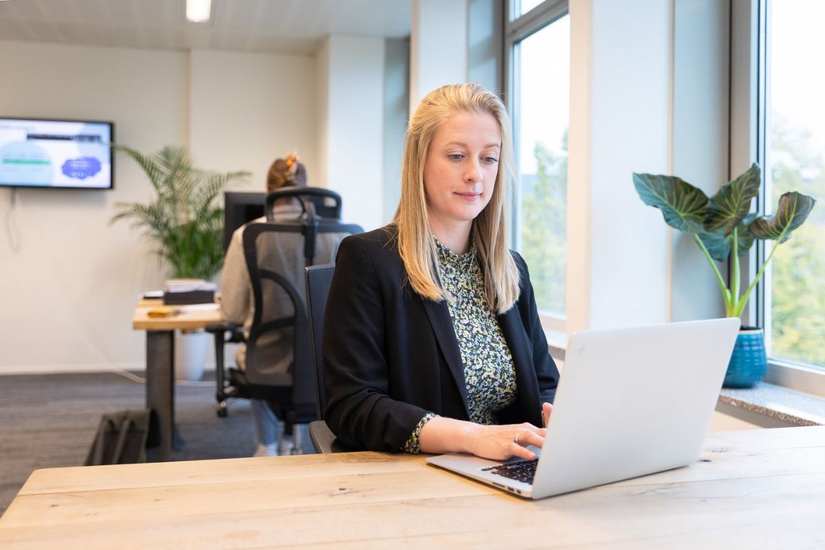Kvinna i kontormiljö som sitter vid en dator