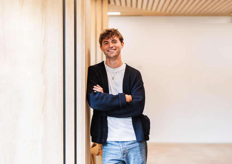 man i stilren kontorsmiljö som står med armarna i kors