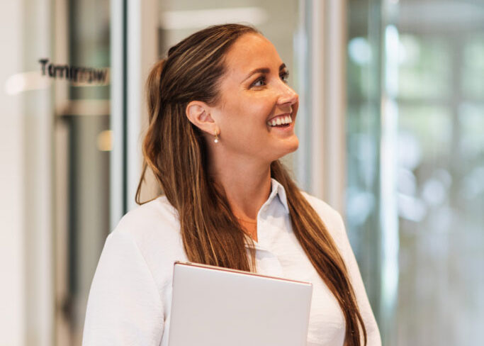 Woman in a white shirt in an office environment.