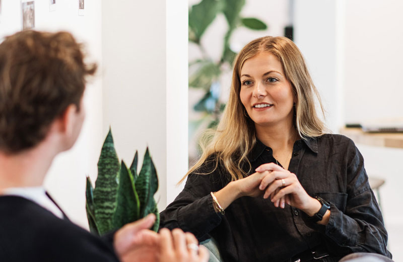Smiling female job candidate being interviewed in office by a man