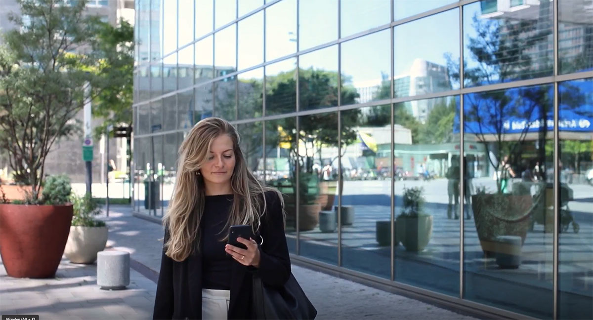 Women walking in the street reading on her phone