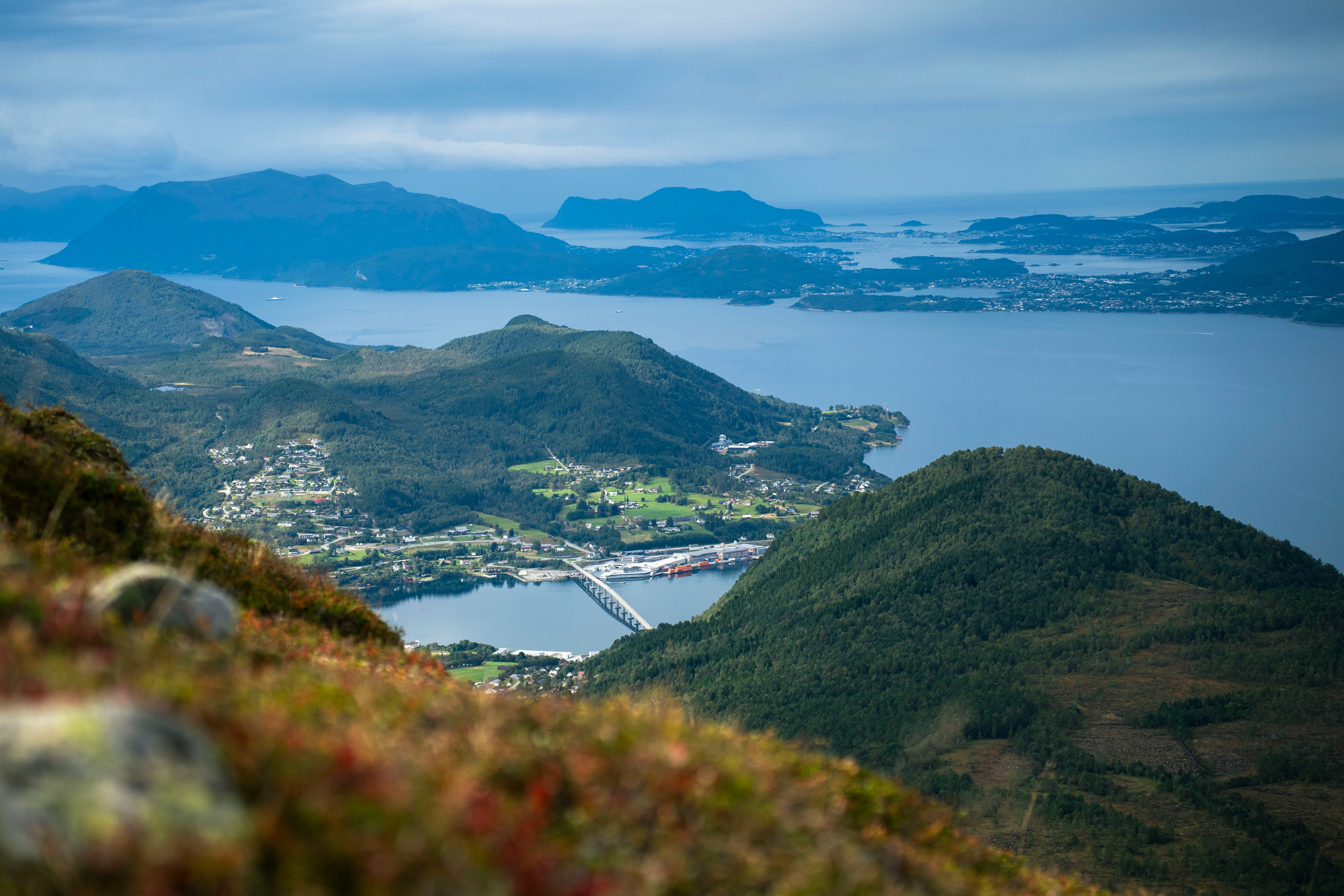 Norskt fjordlandskap och konturer av en stad