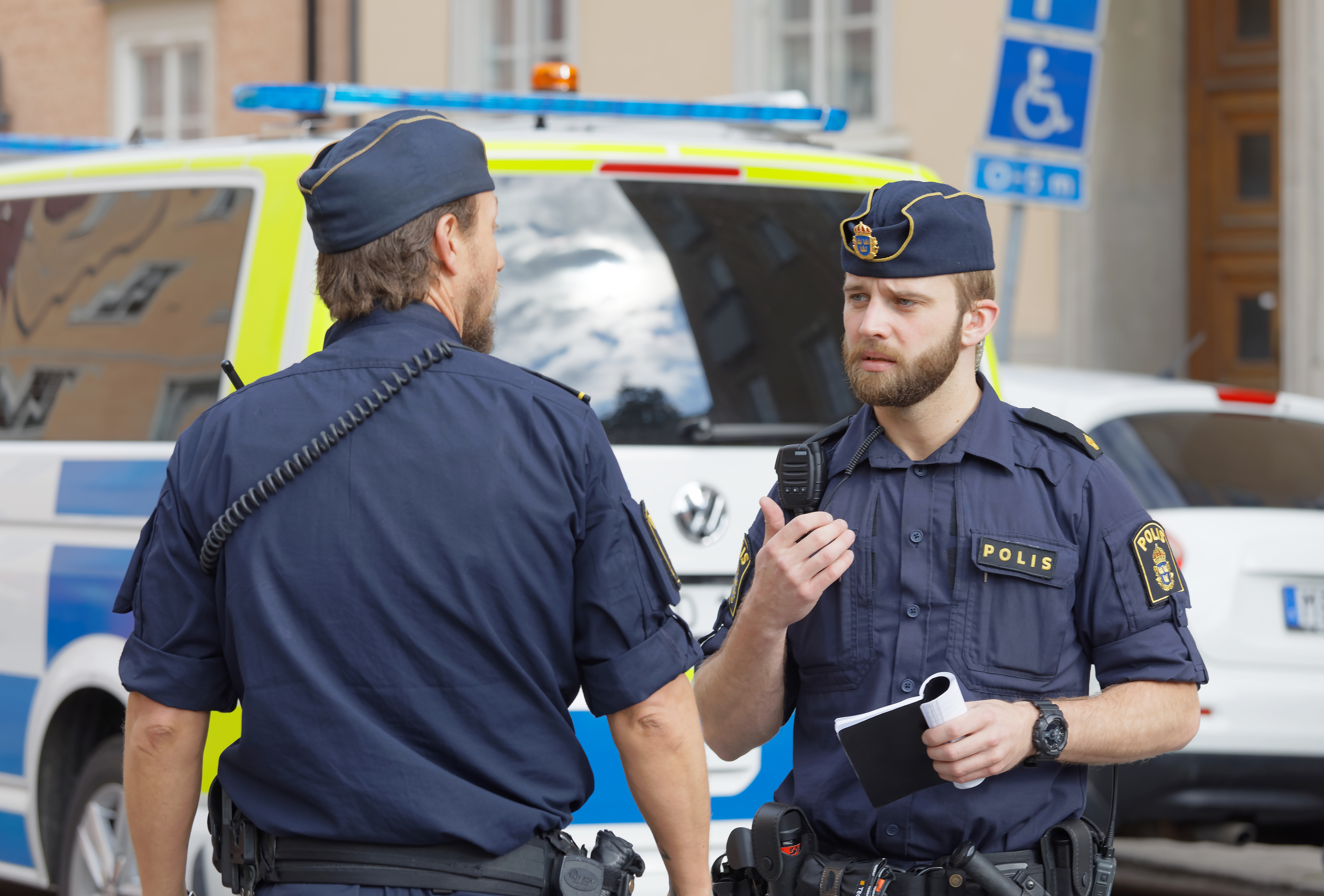 Two police officers talking to each other in the street