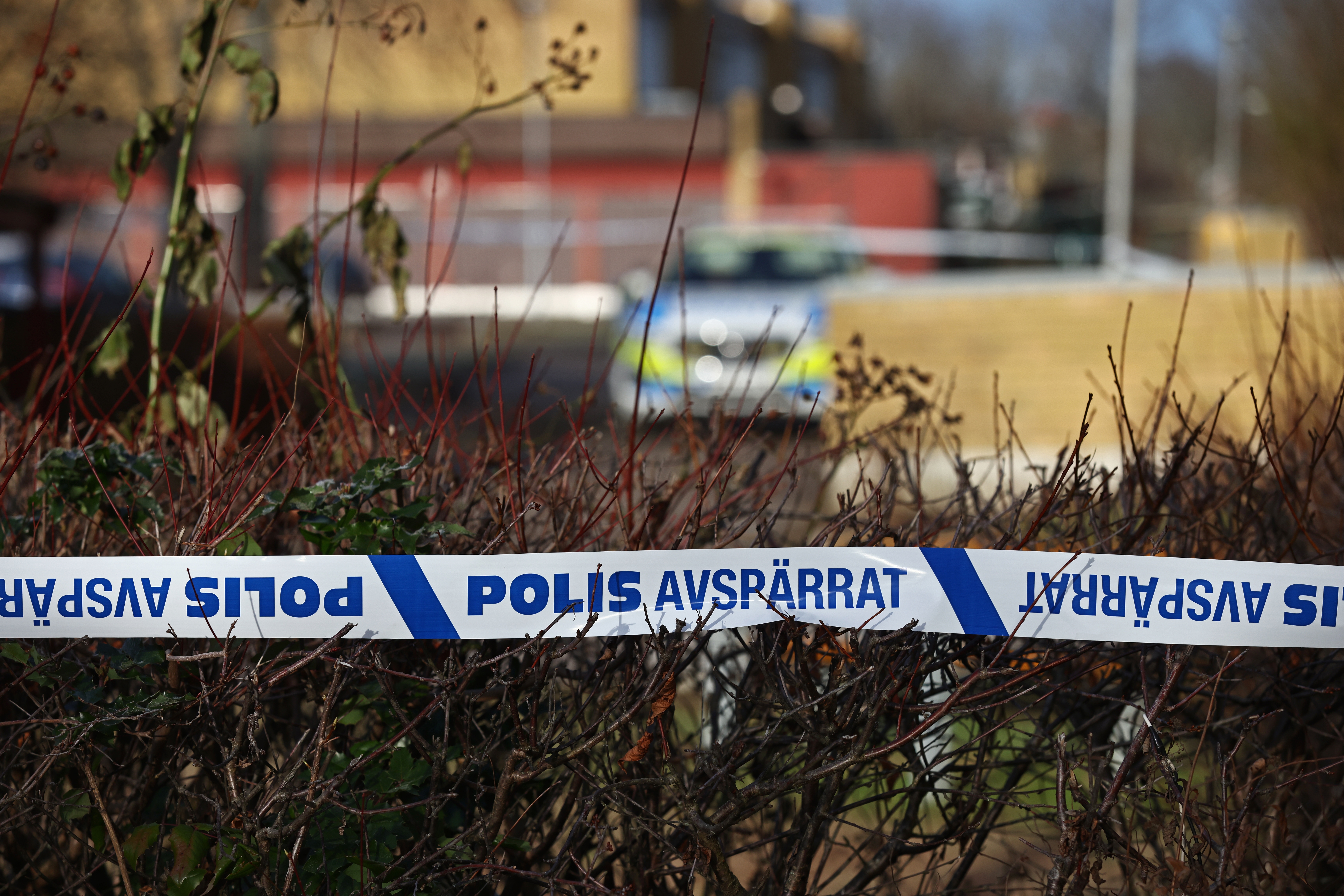 I bakgrunden syns en polisbil och i framkant en polisavspärrning
