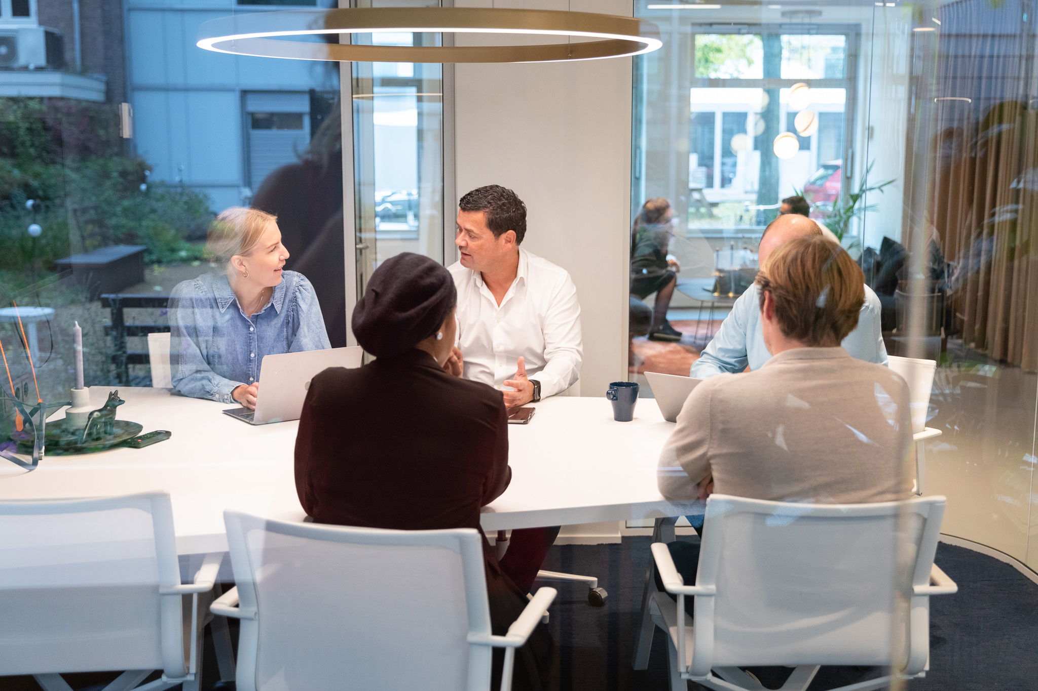 Grupp av kollegor sitter runt ett bord och diskuterar