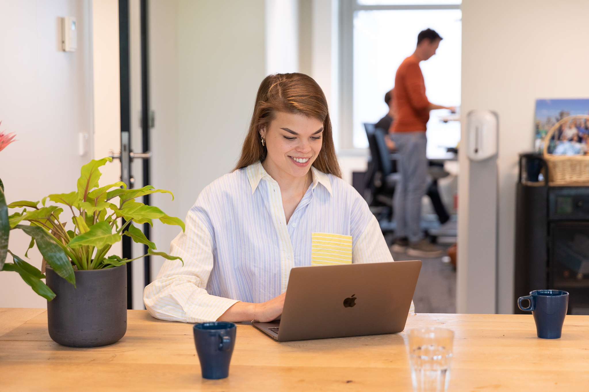 A woman sitting in front of a computer in an office environment.