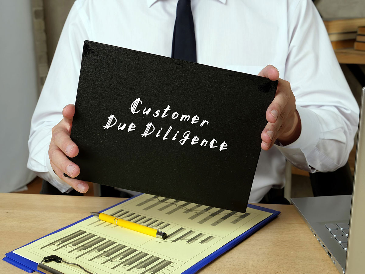 man holding a folder labeled "Customer Due Diligence"
